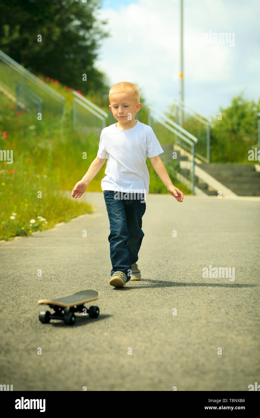 Active childhood. Little man skateboarding. Skater boy child playing on  park alley with skateboard. Outdoor Stock Photo - Alamy