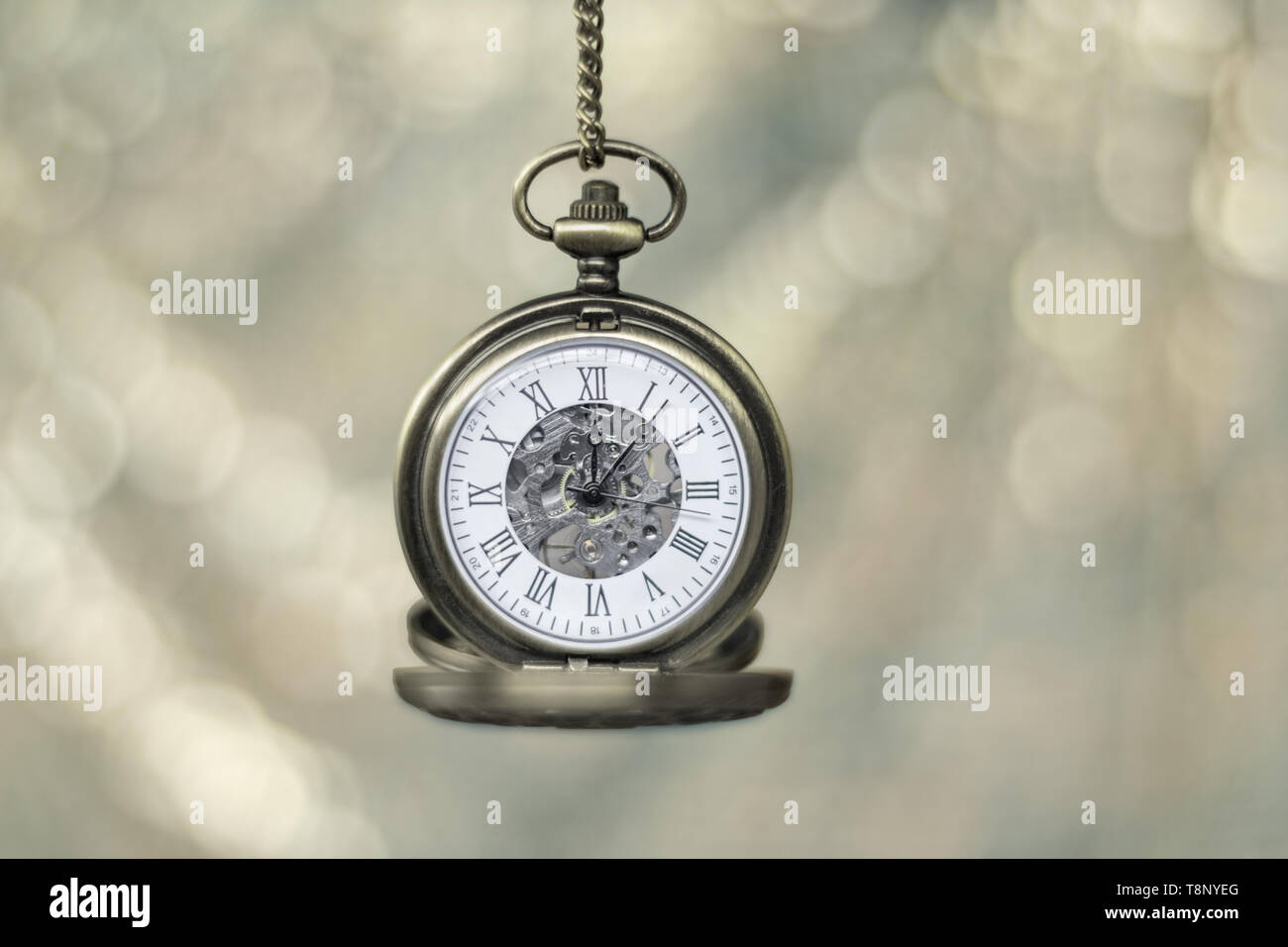 Gold pocket watch isolated against a bokeh background, with copy space. Stock Photo