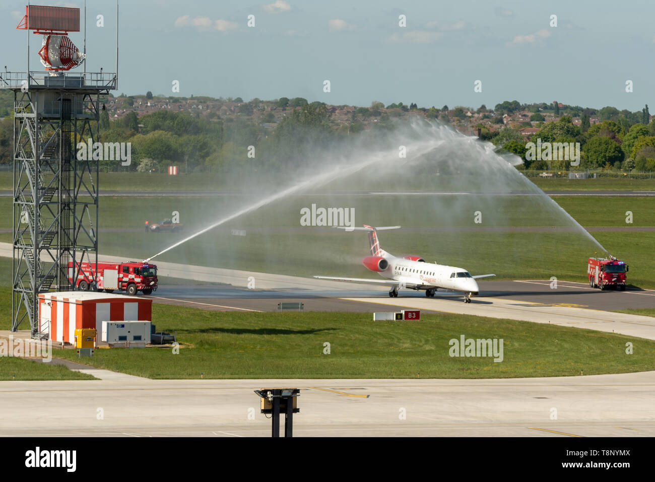 Loganair Embraer ERJ135 at London Southend Airport, Essex, UK. Traditional water arch salute supplied by the airport's fire trucks welcoming launch Stock Photo
