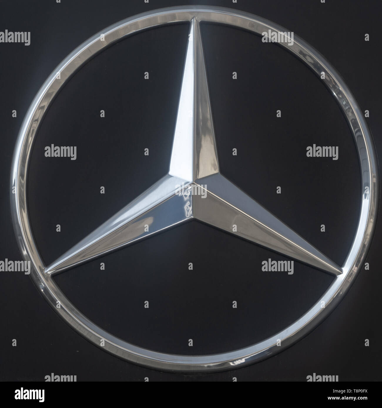 Braunschweig, Germany, April 7., 2019: Logo of the Mercedes Daimler Benz brand from a chrome star with three teeth against a dark background. Stock Photo