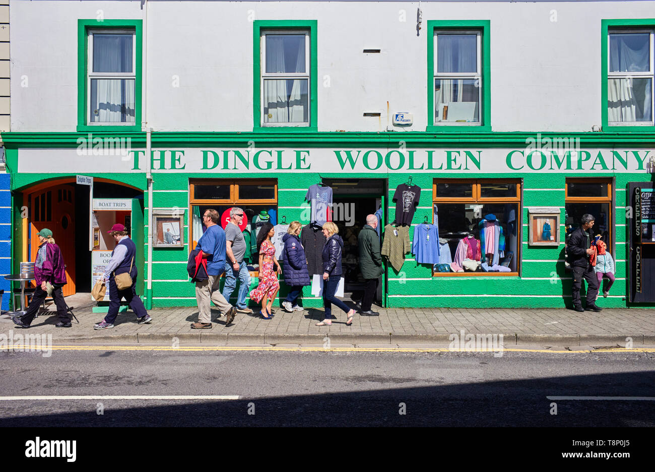 Tourists passing the Dingle woollen clothing shop in Strand Street, County Kerry, Ireland Stock Photo