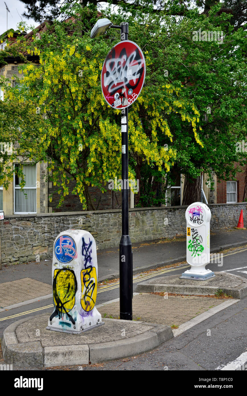 Modern British traffic signs and bollards vandalized with tagging and graffiti Stock Photo