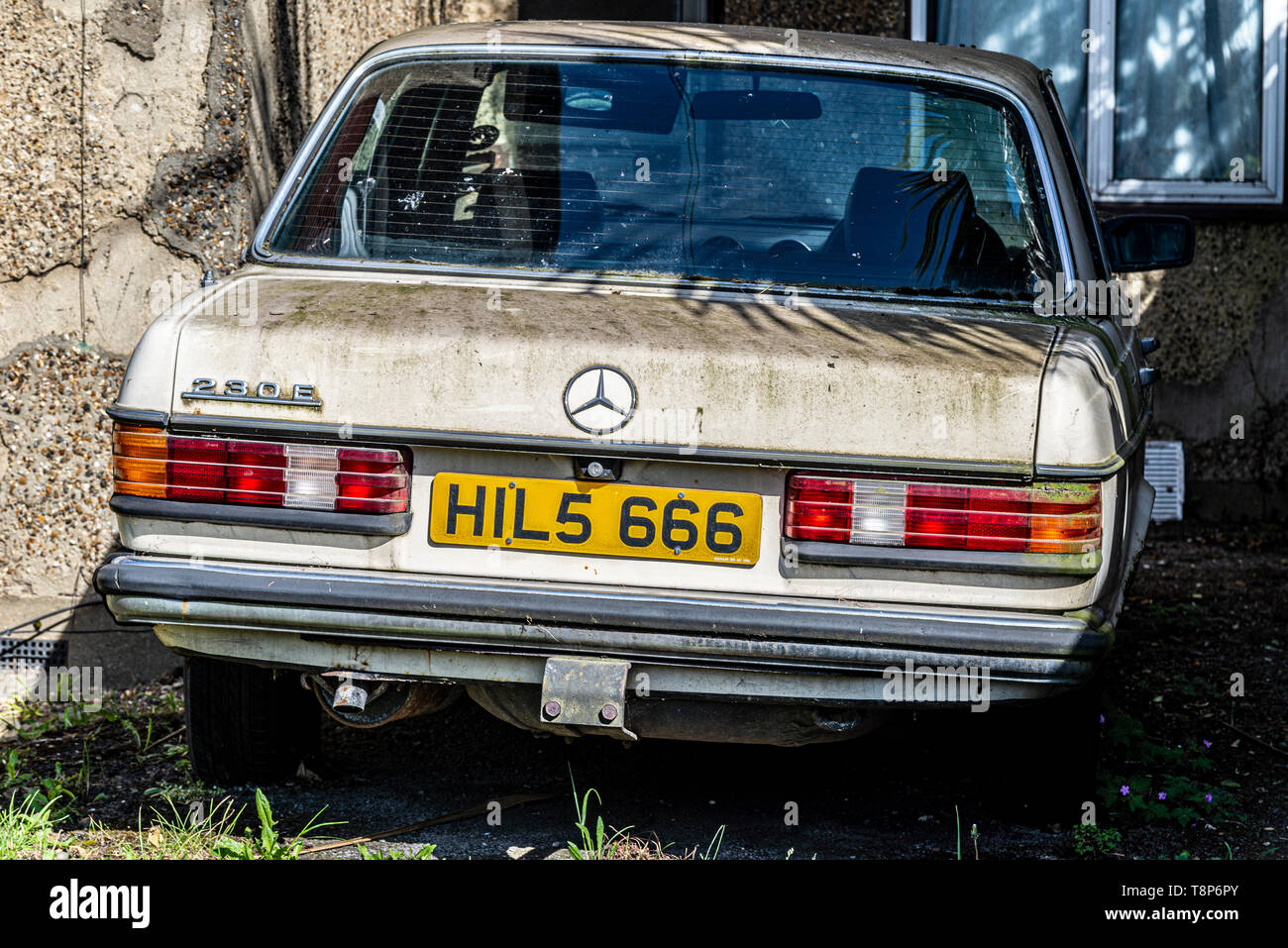 Mercedes 230E saloon car looking forlorn. Special number plate HILS 666 number of the beast registration plate. HIL 5666. Green algae growth Stock Photo
