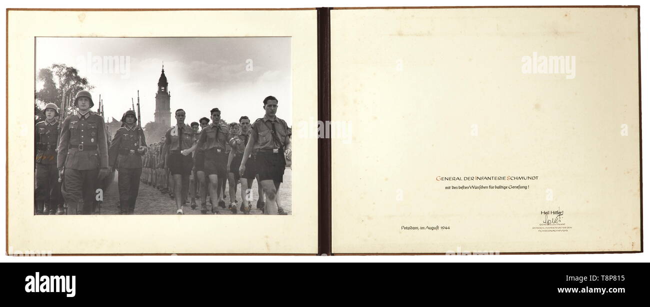 General of Infantry Rudolf Schmundt - a photograph folder presented by General Specht Large-size photograph of an army unit marching alongside Hitler Youth in front of the Potsdam Garrison Church, in a specially made brown presentation folder with the inscription '13. AUGUST MCMXLIV' and the dedication (tr.) 'FOR GENERAL OF THE INFANTRY SCHMUNDT with best wishes for a speedy recovery!', issued 'Potsdam, im August 1944' and signed by Lieutenant General Karl-Wilhelm Specht, inspector general for the junior leadership units. Rudolf Schmundt, the chief of the army personnel off, Editorial-Use-Only Stock Photo