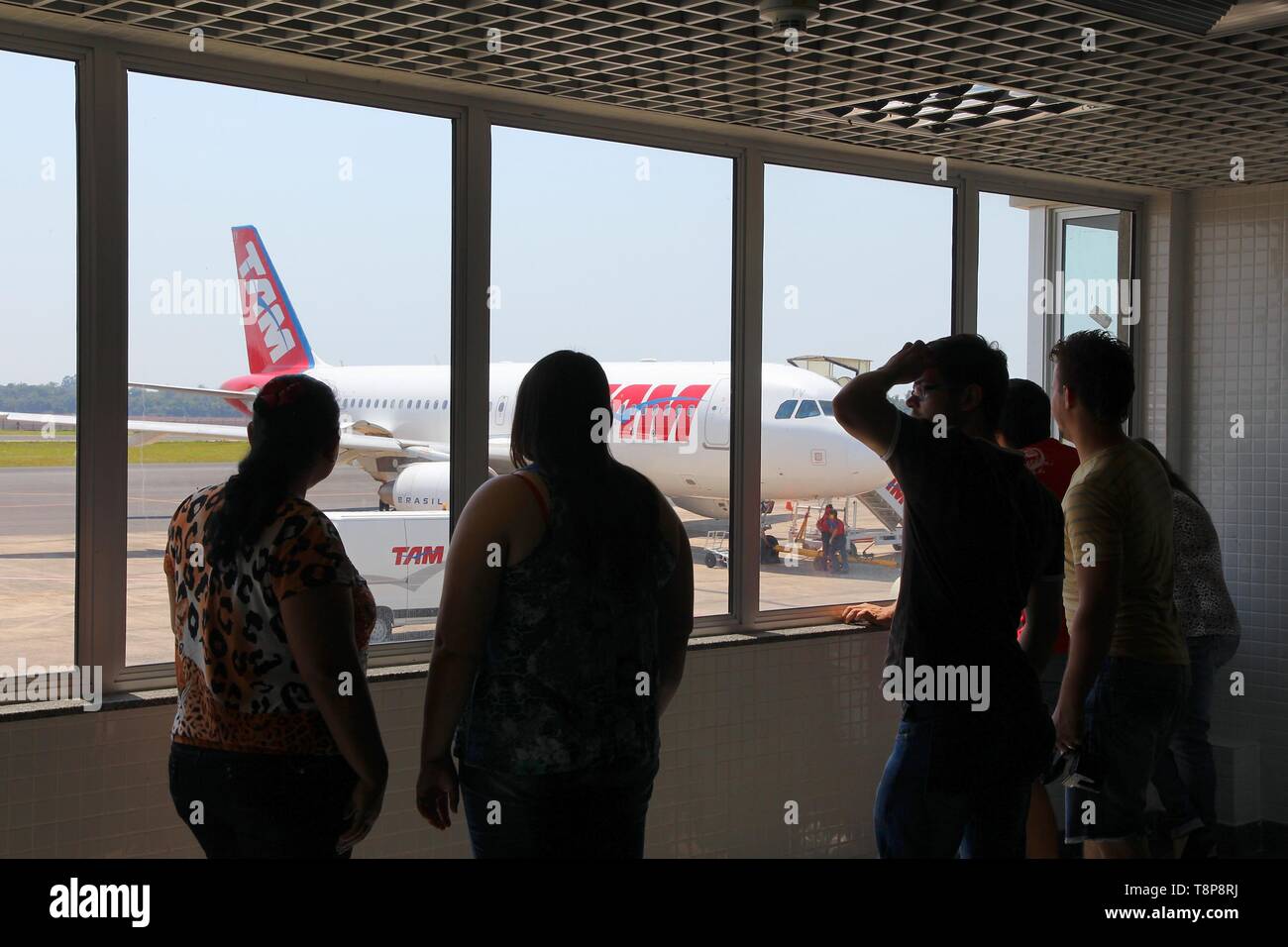 FOZ DO IGUACU, BRAZIL - OCTOBER 12, 2014: Passengers look at TAM Airlines Airbus A320 at Foz do Iguacu Airport, Brazil. In 2013 TAM Airlines carried 3 Stock Photo