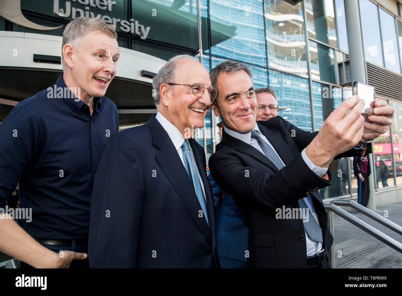 (left to right) Comedian Patrick Kielty, Senator George Mitchell, Dr James Nesbitt and Vice-Chancellor of Ulster University Paddy Nixon, take a selfie following an address by the senator during a conference at the university's Belfast campus on ending sectarianism. A new government department should be created in Northern Ireland to specifically deal with tackling sectarianism, an Ulster University academic report has urged. Stock Photo