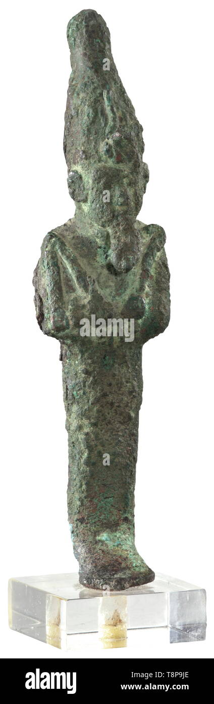 An ancient Egyptian bronze statuette of Osiris, Late Period, mid- to end of the 1st millennium BC Hollow, upright standing figure of the god as mummy with hedjet (white Crown of the South), holding crook and flail against his chest. The surface is corroded, the right side along the small slit is split open. On a plastic base. Length 13.2 cm. Provenance: 1970s private collection from the Munich area. historic, historical, ancient world, Additional-Rights-Clearance-Info-Not-Available Stock Photo