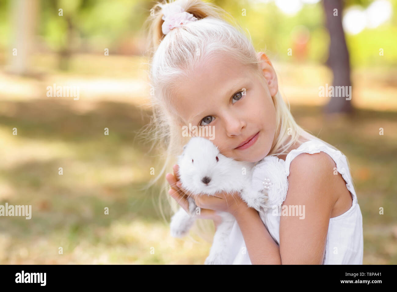 Little girl with cute rabbit outdoors Stock Photo - Alamy