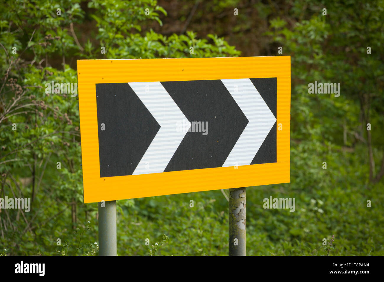 A reflective chevron sign indicating a sharp right-hand bend in countryside near Henley-on-Thames Stock Photo
