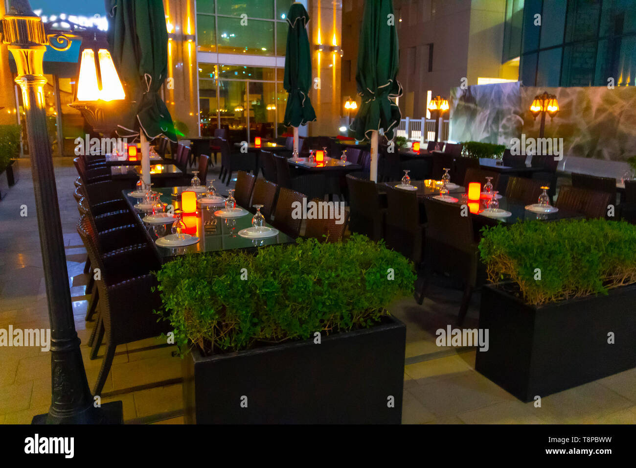 Dubai, UAE - November 28, 2018: Covered tables at an outdoor Dubai cafe evening. Stock Photo