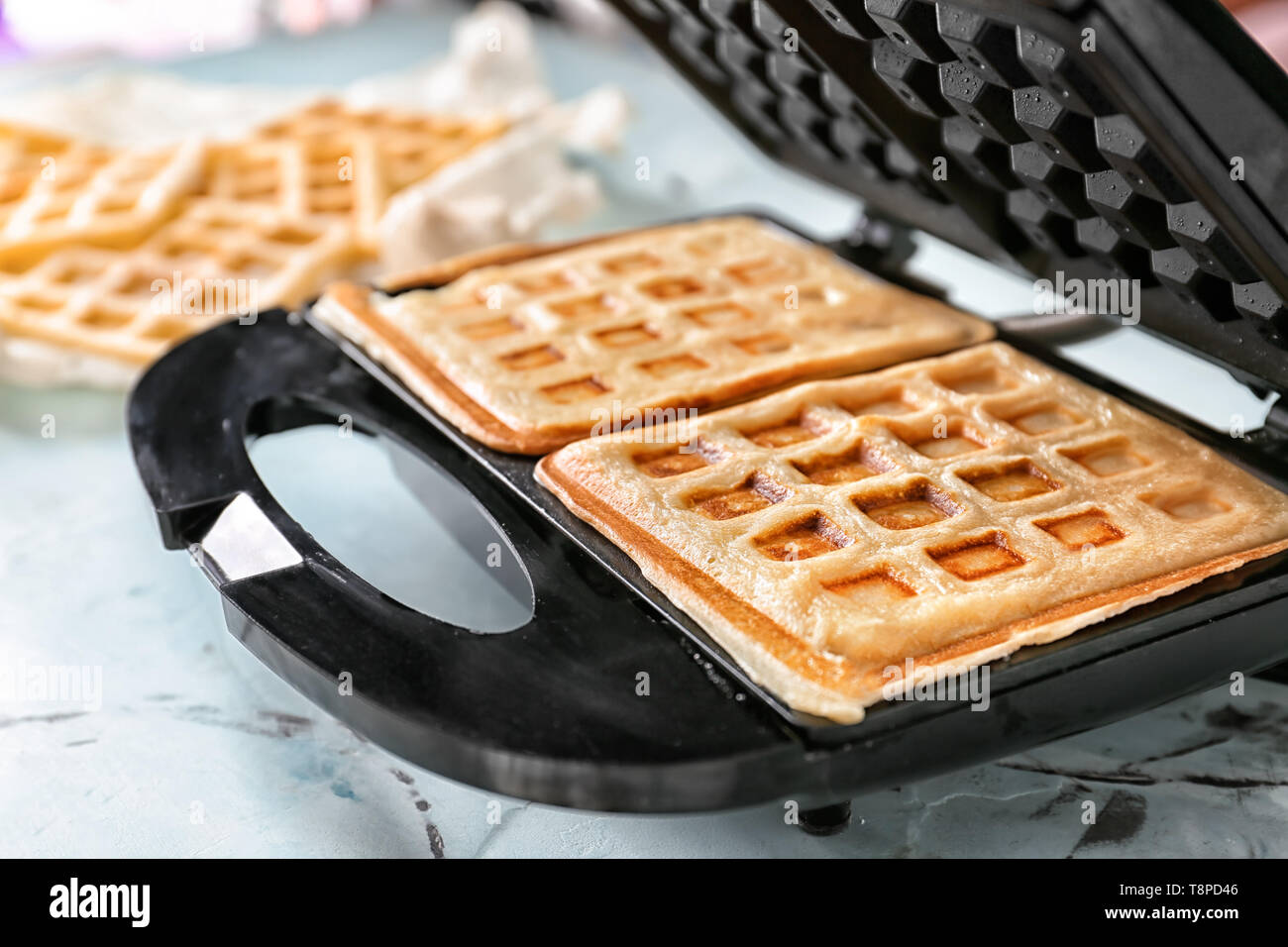 https://c8.alamy.com/comp/T8PD46/preparing-of-waffles-in-modern-maker-on-light-table-T8PD46.jpg