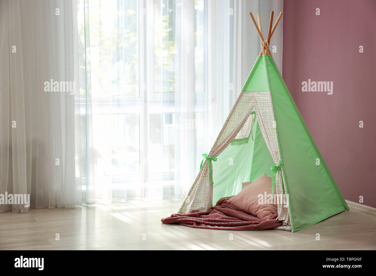 Cozy play tent for kids near window in room Stock Photo