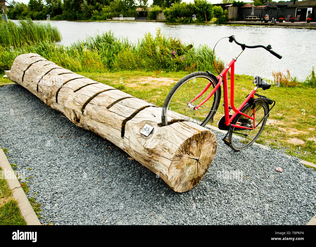 parked bike in an unusual wooden tree bike stand,just off the canal bank cycle path. Stock Photo