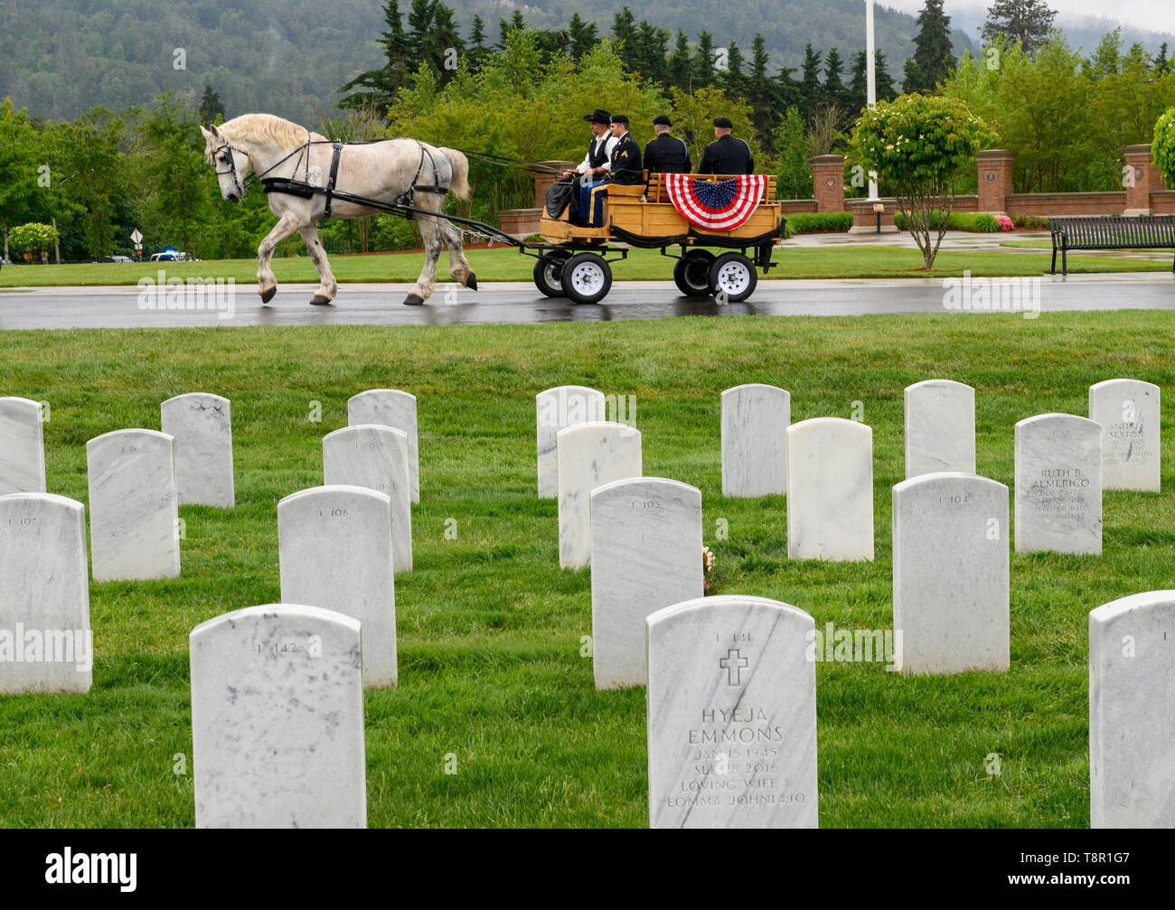 Roseburg, OREGON, USA. 14th May, 2019. The unclaimed cremated remains of four World War I veterans are transported by horse drawn buggy through the Roseburg National Cemetery in souther Oregon. Twenty-eight veterans, whose remains were discovered in storage at a Roseburg funeral home and waited unclaimed for as long as 44 years, are finally being laid to rest at the cemetery. Credit: Robin Loznak/ZUMA Wire/Alamy Live News Stock Photo