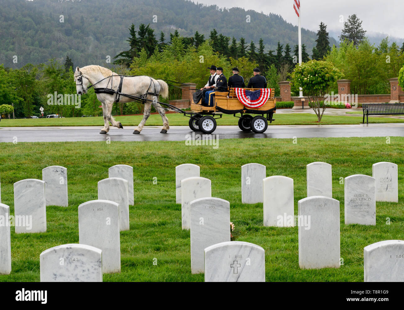 Roseburg, OREGON, USA. 14th May, 2019. The unclaimed cremated remains of four World War I veterans are transported by horse drawn buggy through the Roseburg National Cemetery in souther Oregon. Twenty-eight veterans, whose remains were discovered in storage at a Roseburg funeral home and waited unclaimed for as long as 44 years, are finally being laid to rest at the cemetery. Credit: Robin Loznak/ZUMA Wire/Alamy Live News Stock Photo