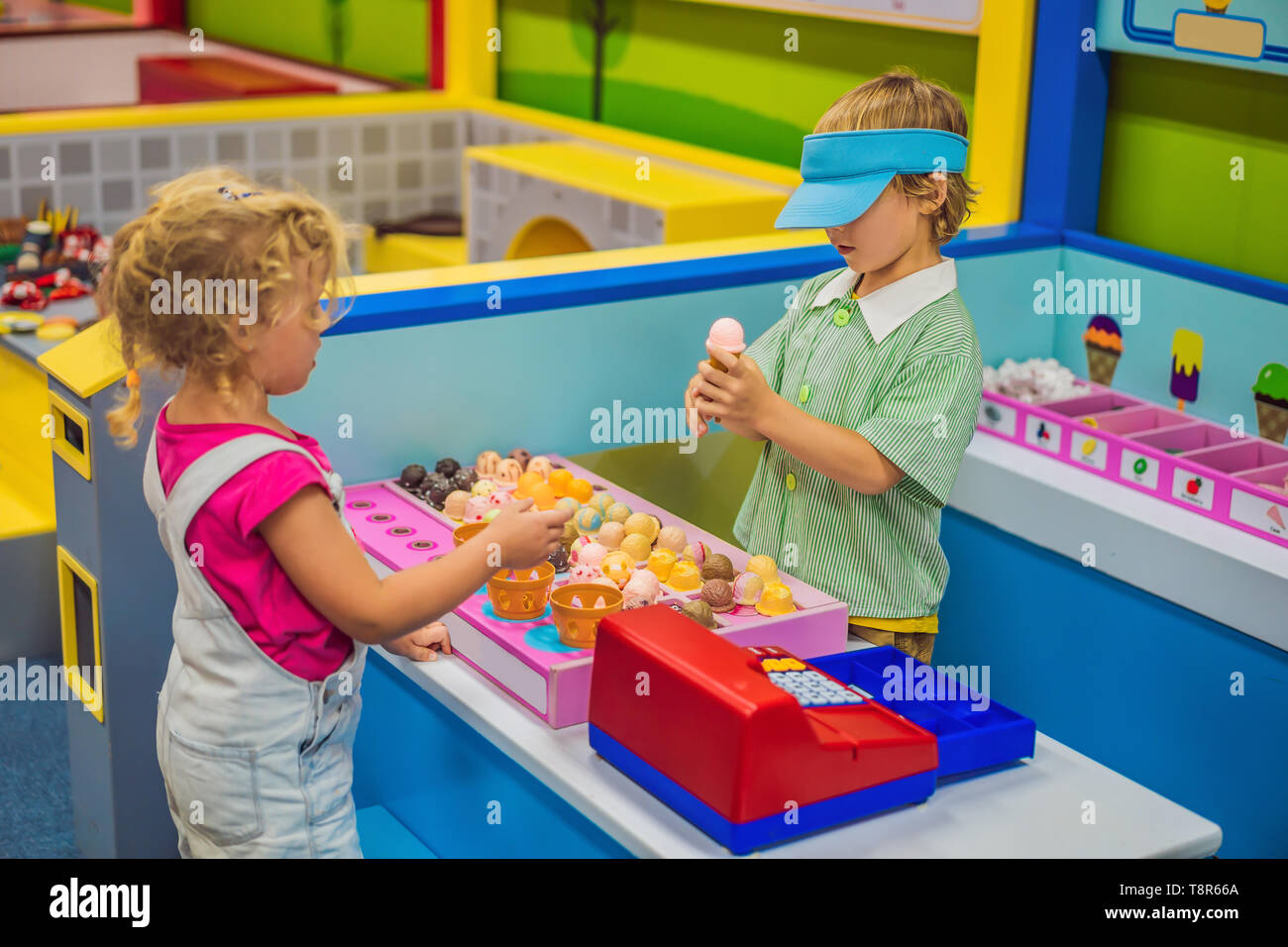 Boy And Girl Playing In The Toy Kitchen Making Toy Ice Cream