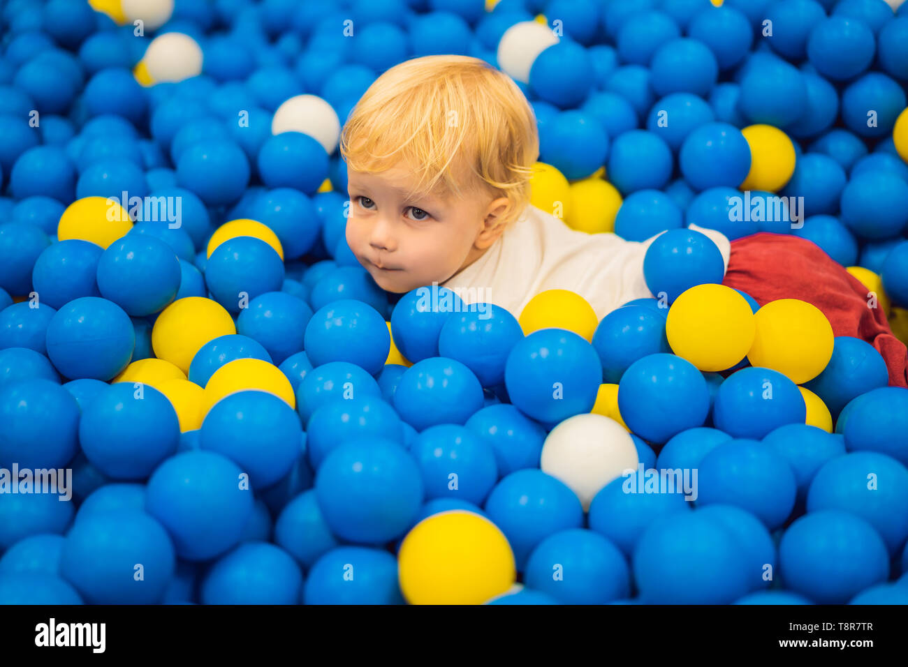Child playing in ball pit. Colorful toys for kids. Kindergarten or