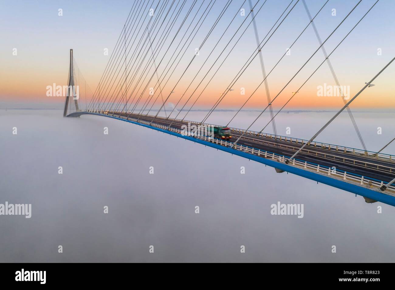 France, between Calvados and Seine Maritime, the Pont de Normandie (Normandy Bridge) emerges from the morning mist of autumn and spans the Seine to connect the towns of Honfleur and Le Havre Stock Photo