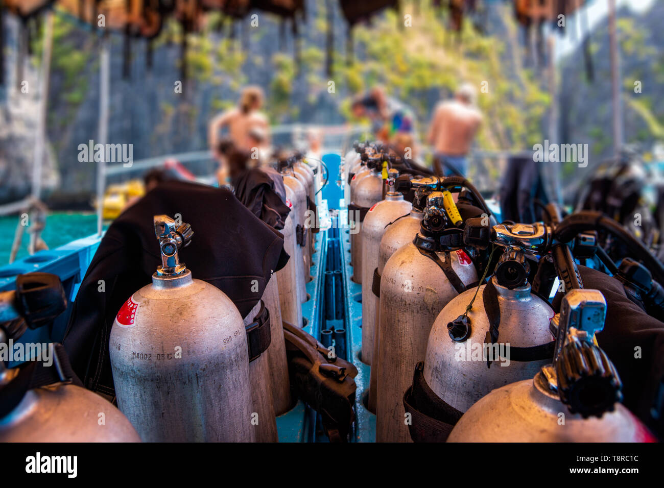 Scuba divers getting ready for diving on a boat full of equipment