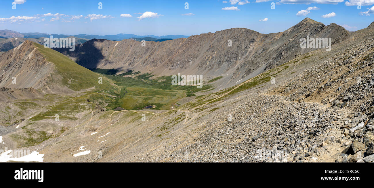 Mountain Trail - Panorama of rugged hiking trails winding down rocky hills and through a green valley at base of Grays Peak in Front Range. CO, USA. Stock Photo