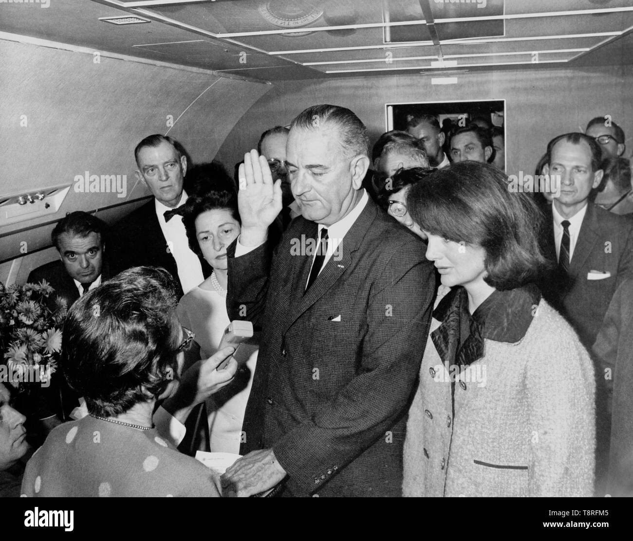 Lyndon B. Johnson taking the oath of office aboard Air Force One at Love Field Airport two hours and eight minutes after the assassination of John F. Kennedy, Dallas, Texas. Jackie Kennedy, still in her blood-soaked clothes, looks on. November 22, 1963 Stock Photo