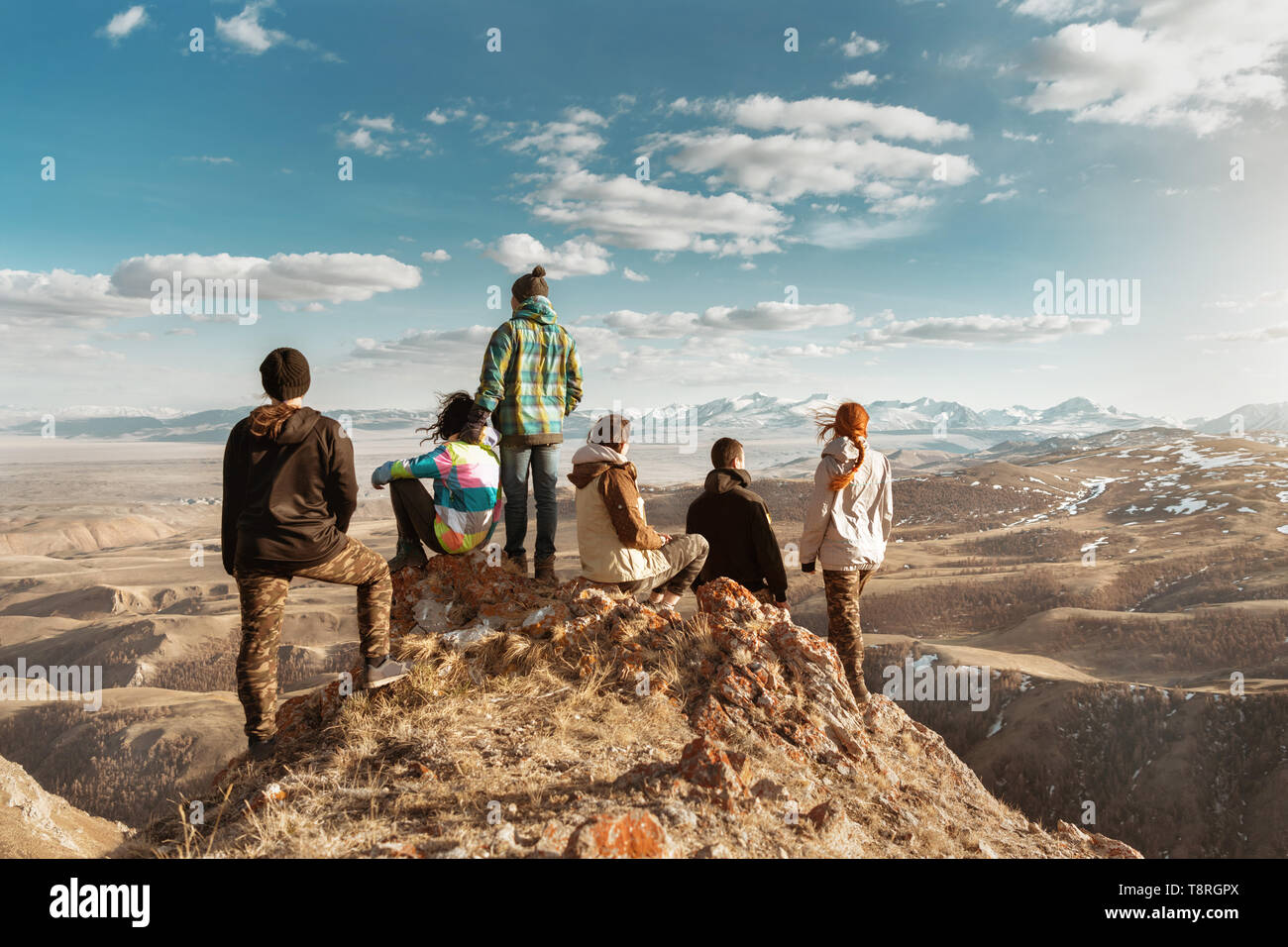 Group of tourists or friends stands at viewpoint and looks at mountains Stock Photo