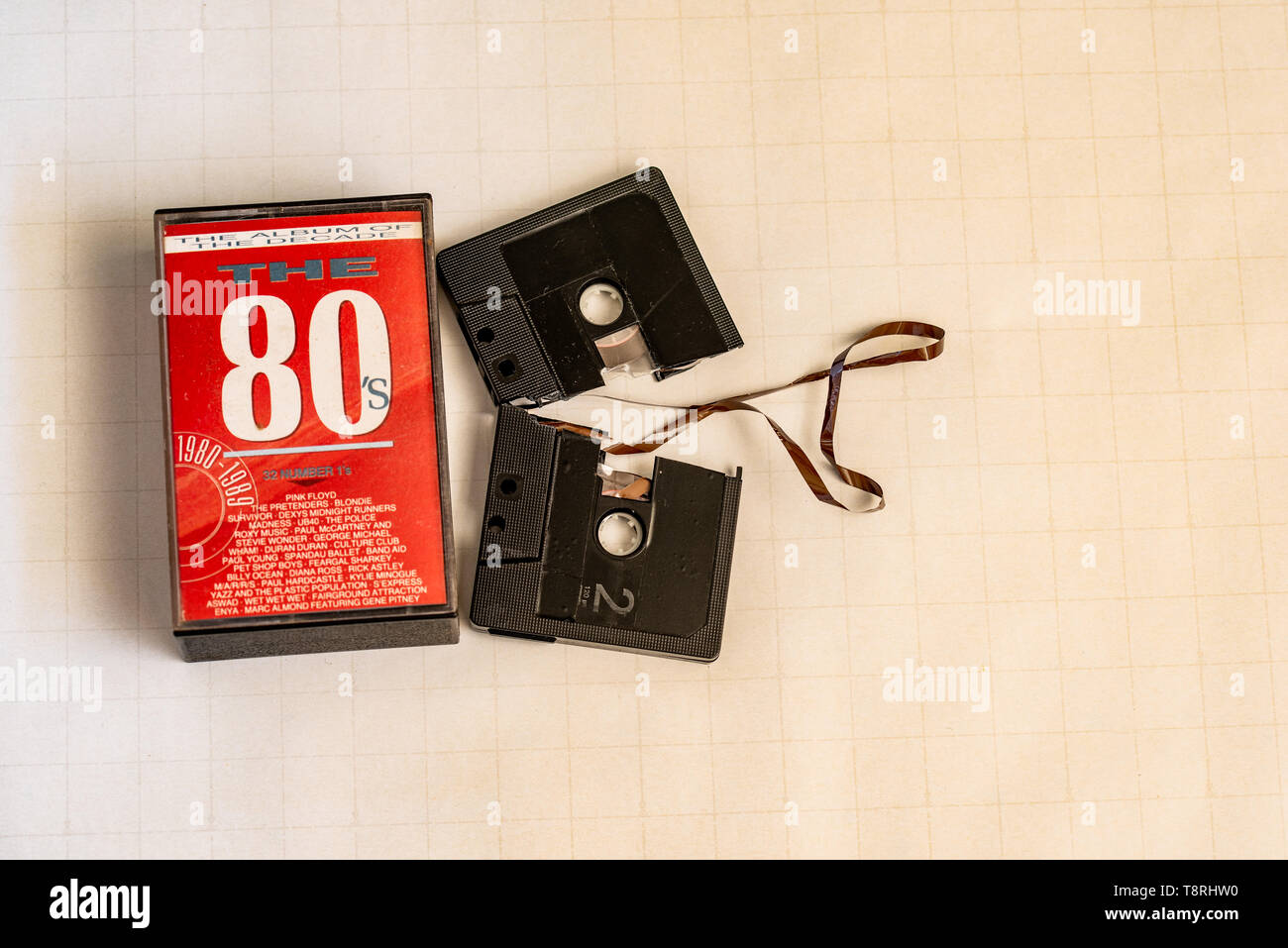 A broken 80's cassette and cassette case. Stock Photo