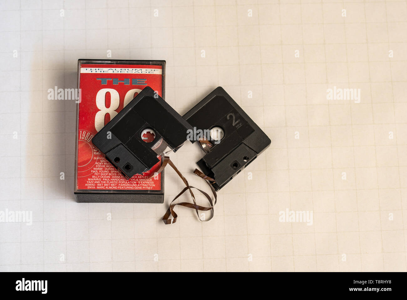 A broken 80's cassette and cassette case. Stock Photo