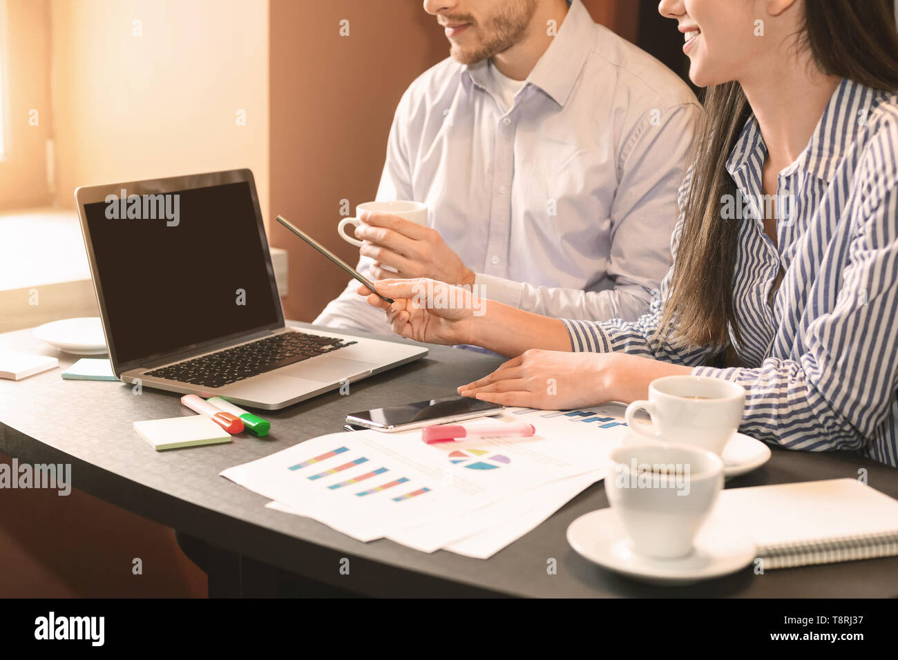 Coworkers discussing strategy, analyzing statistics on laptop Stock Photo