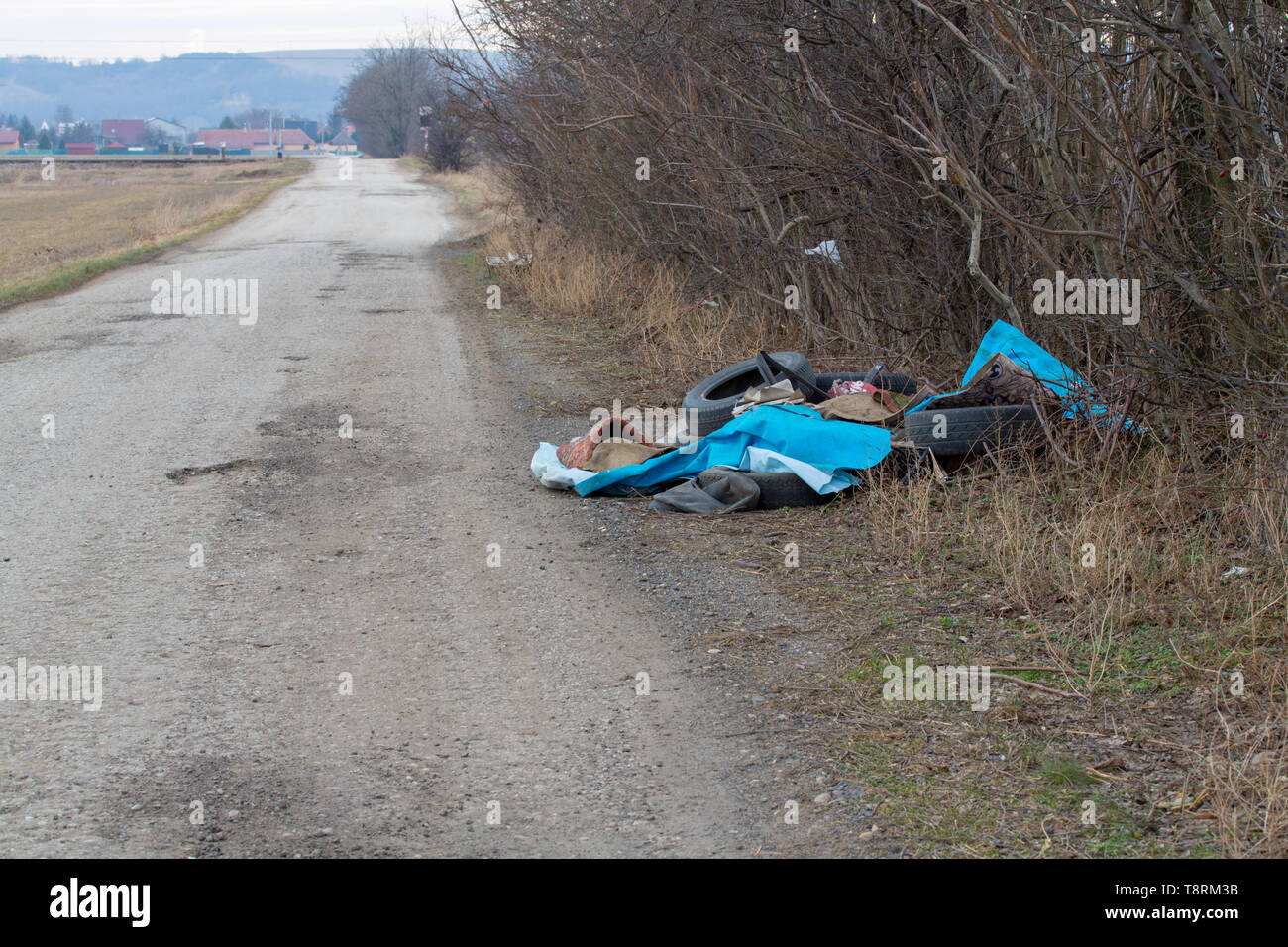 Fly tipped rubbish dumped in a lay-by in a country lane. Heap of illegally dumped household rubbish left on a side of the cart-road. Roadside fly tipp Stock Photo