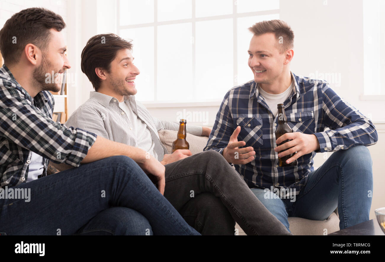 Happy Mates Drinking Beer And Talking At Home Stock Photo