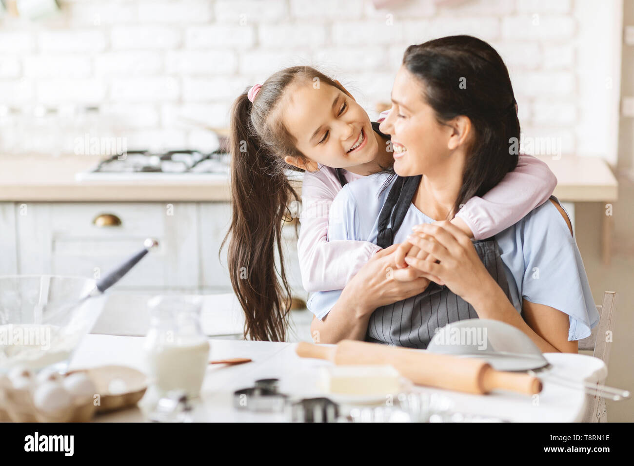 Loving daughter hugging her mother on kitchen. Stock Photo