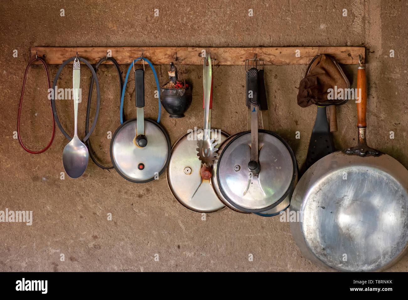 Used and timeworn kitchen utensils on the wall of a popular kitchen in