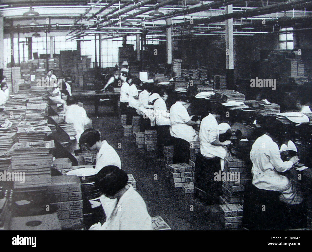 Examining gramophone records at the Gramophone Company Ltd  factory, UK, c1940's. Ir was the parent organisation for the His Master's Voice  music (HMV) label and was founded in 1898 by William Barry Owen and Trevor Williams in London for the inventor of the gramophone record, Emile Berliner Stock Photo