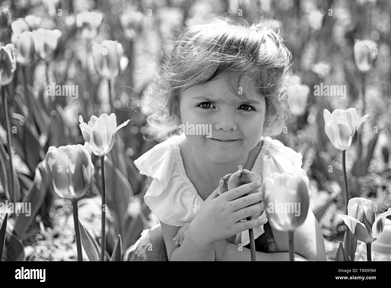 Little girl in sunny spring. Summer girl fashion. Happy childhood. face and skincare. allergy to flower. Springtime tulips. weather forecast. Small Stock Photo