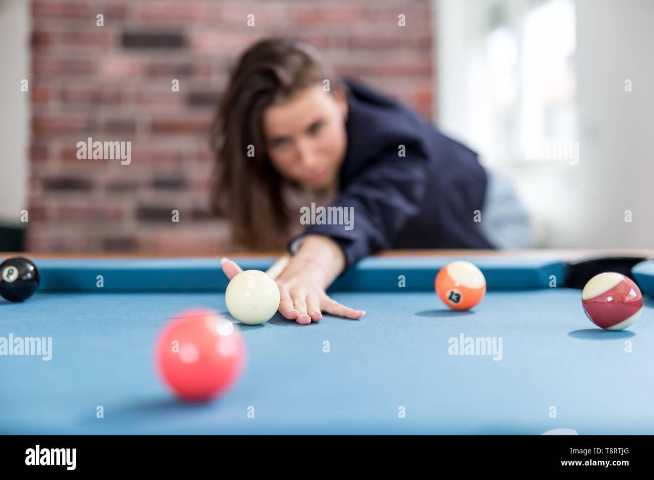 Fashionable modern woman playing pool table billiards game. Stock Photo