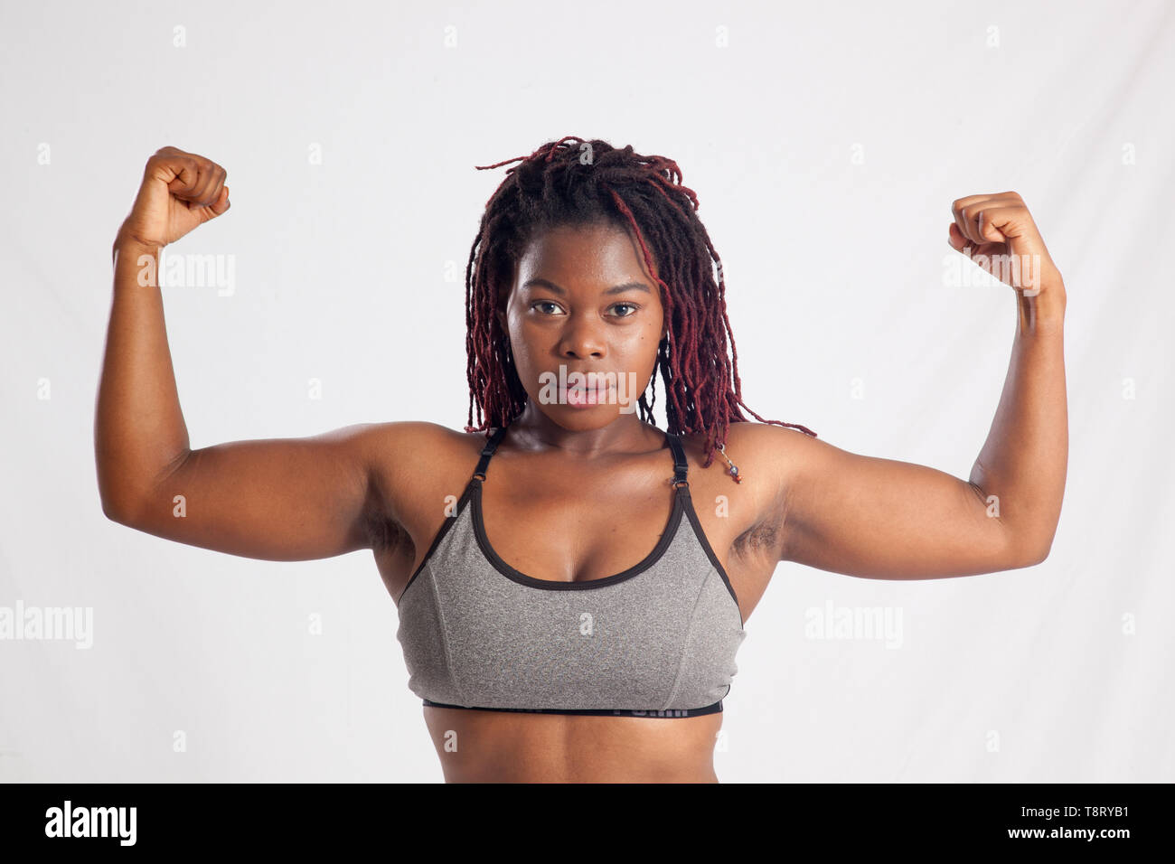 Pretty Black woman flexing her muscles Stock Photo - Alamy