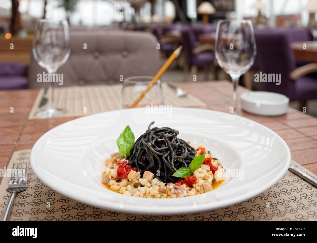 Black squid ink pasta with seafood on restaurant table Stock Photo