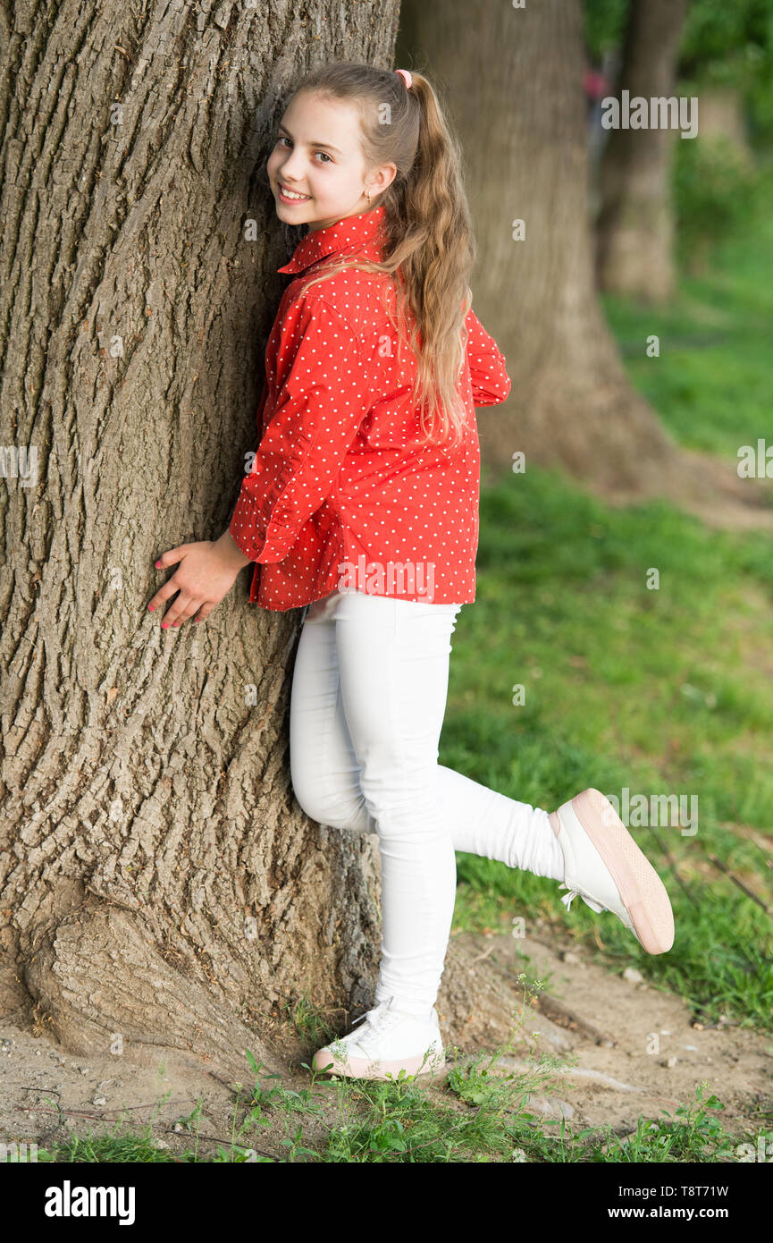 Girl little cute child enjoy peace and tranquility at tree trunk. Calm