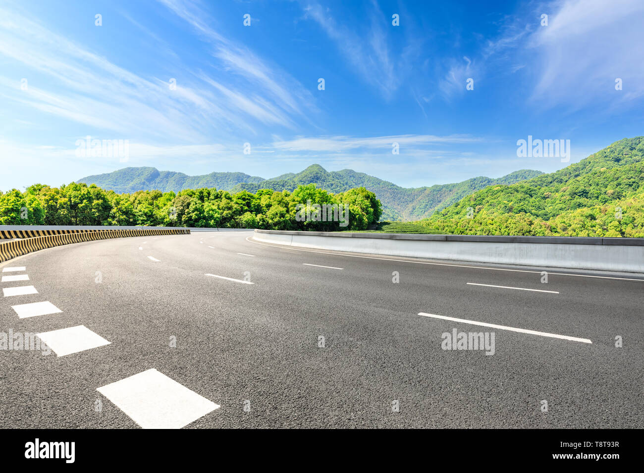 Country road and green mountains natural landscape under the blue sky Stock Photo