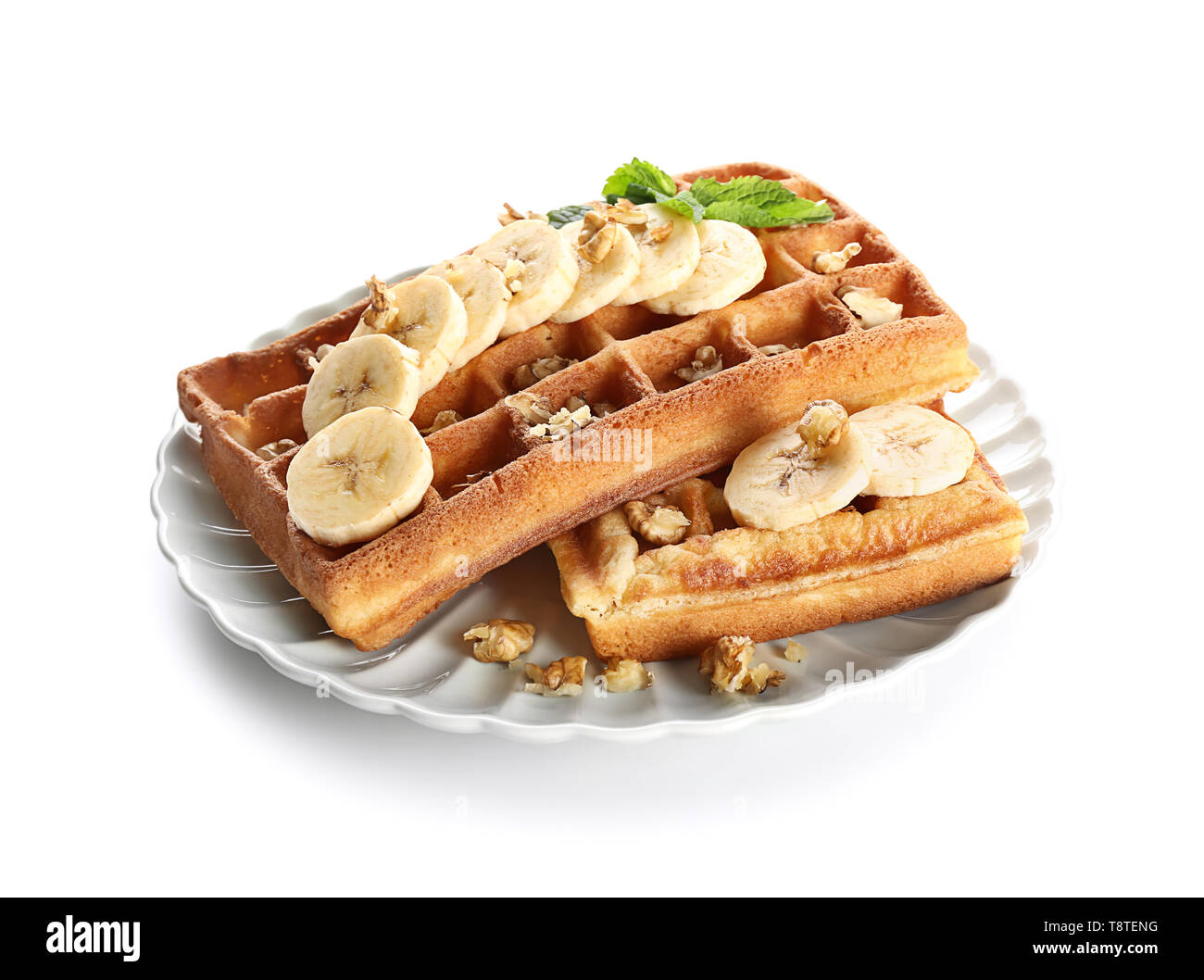 Delicious waffles with banana slices and nuts on white background Stock ...