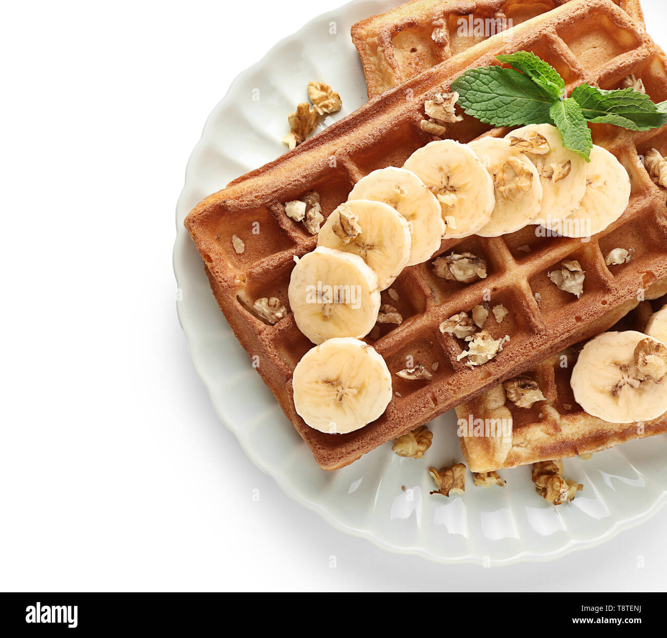 Delicious waffles with banana slices and nuts on white background Stock ...