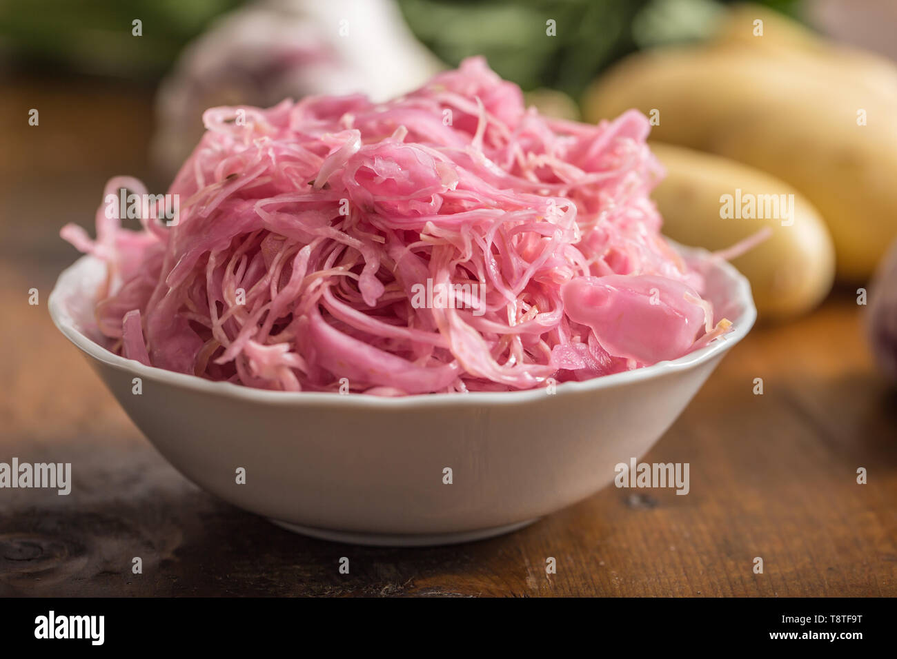 Sour cabbage with potatoes and garlic on wooden table Stock Photo