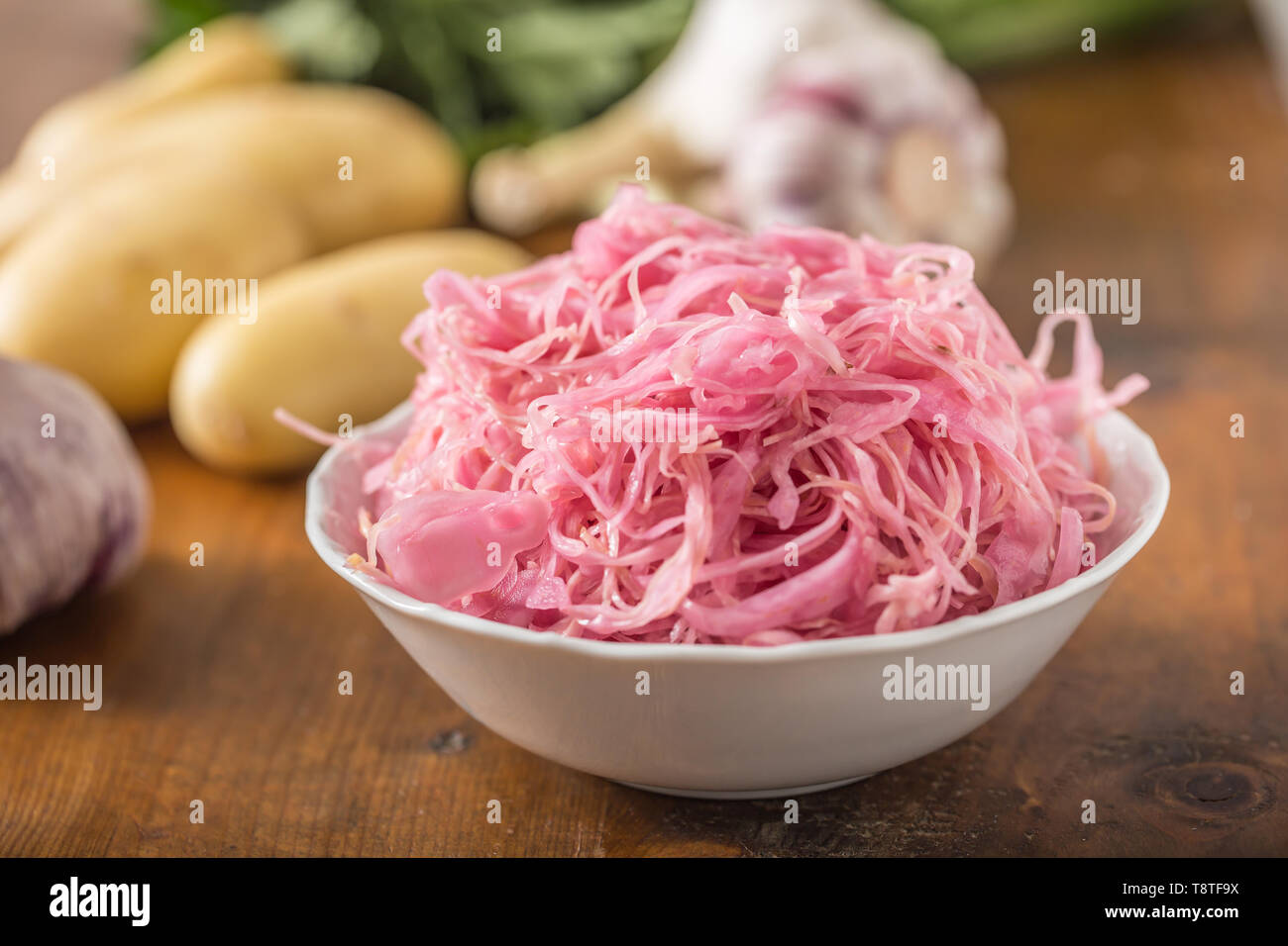 Sour cabbage with potatoes and garlic on wooden table Stock Photo