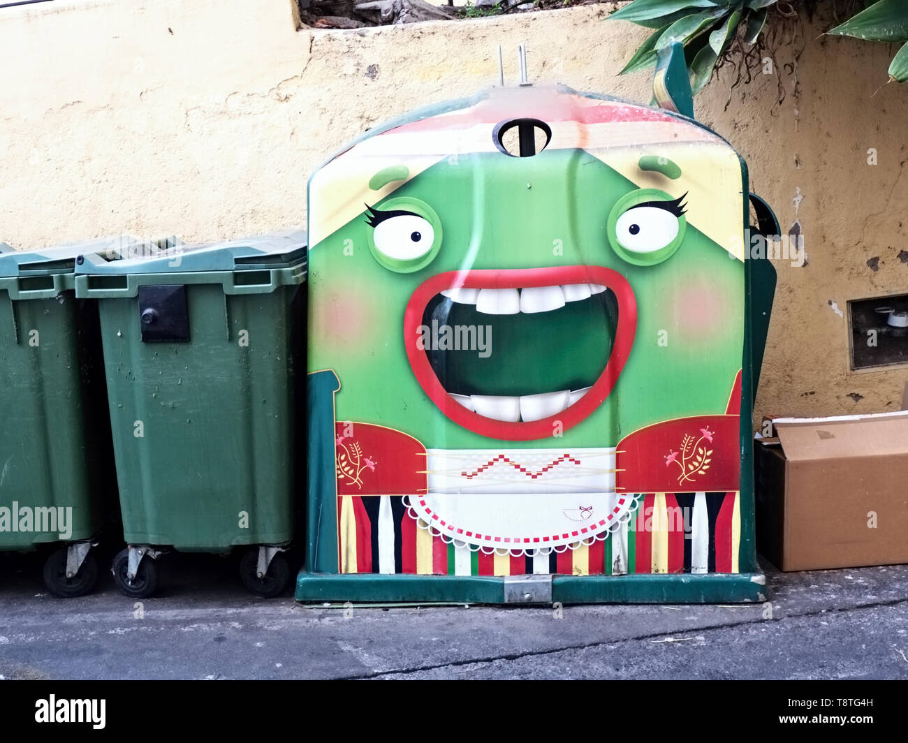 A large dumpster for glass with a special outfit, a big open woman's mouth with red lips and big eyes with black long eyelashes Stock Photo