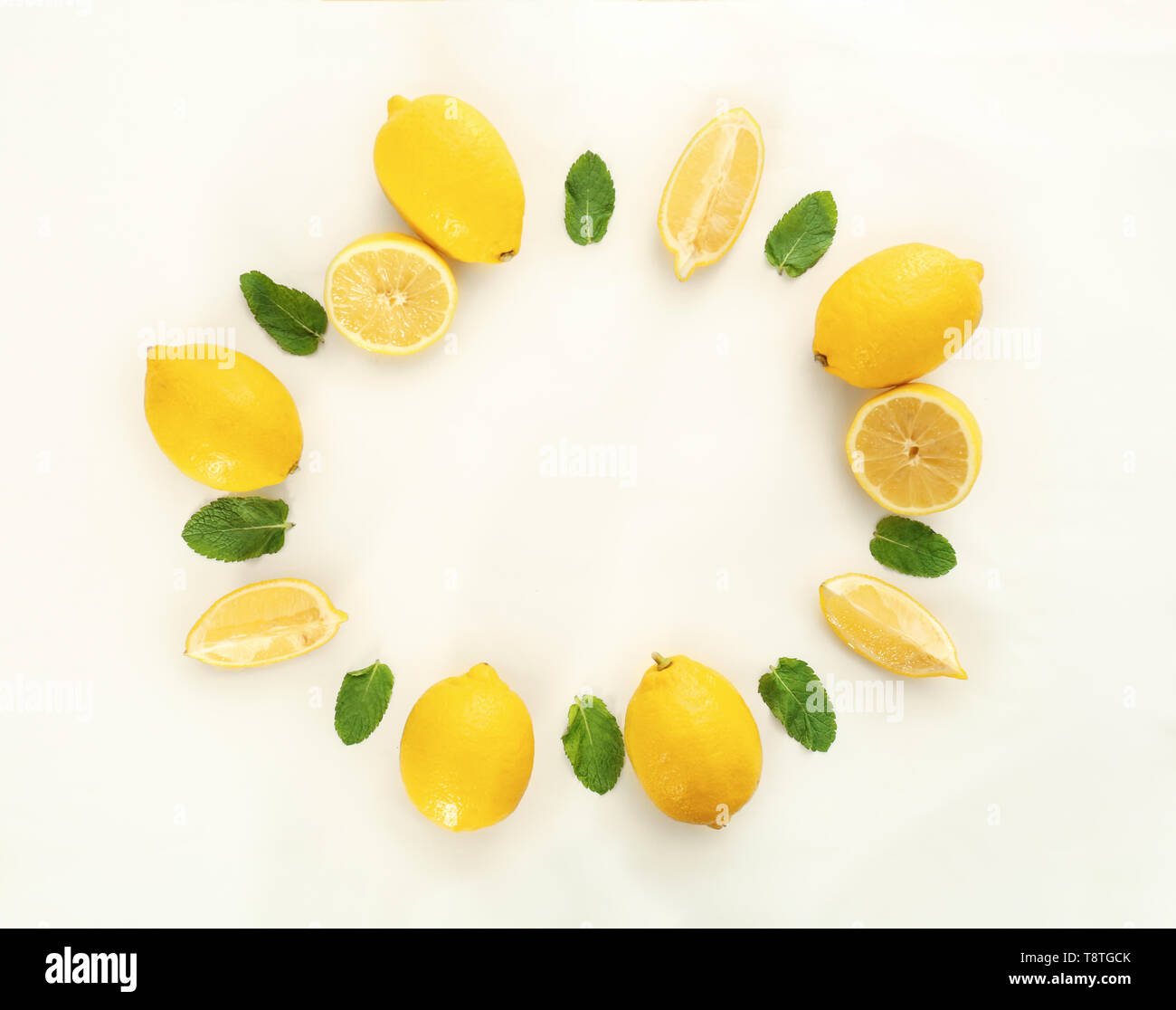 Frame made of fresh lemons and green leaves on white background Stock ...