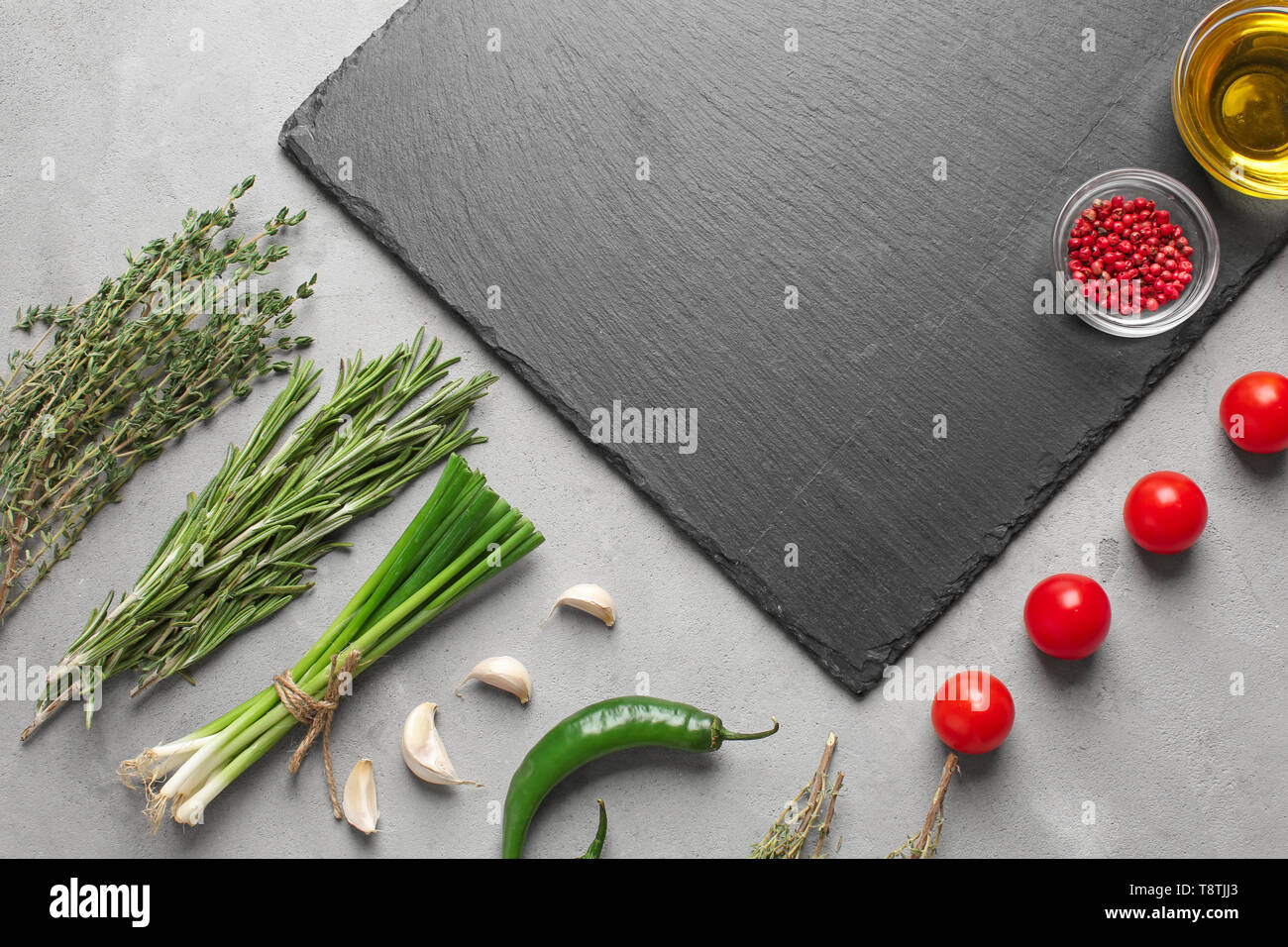Flat lay composition with fresh herbs and slate plate on grey ...