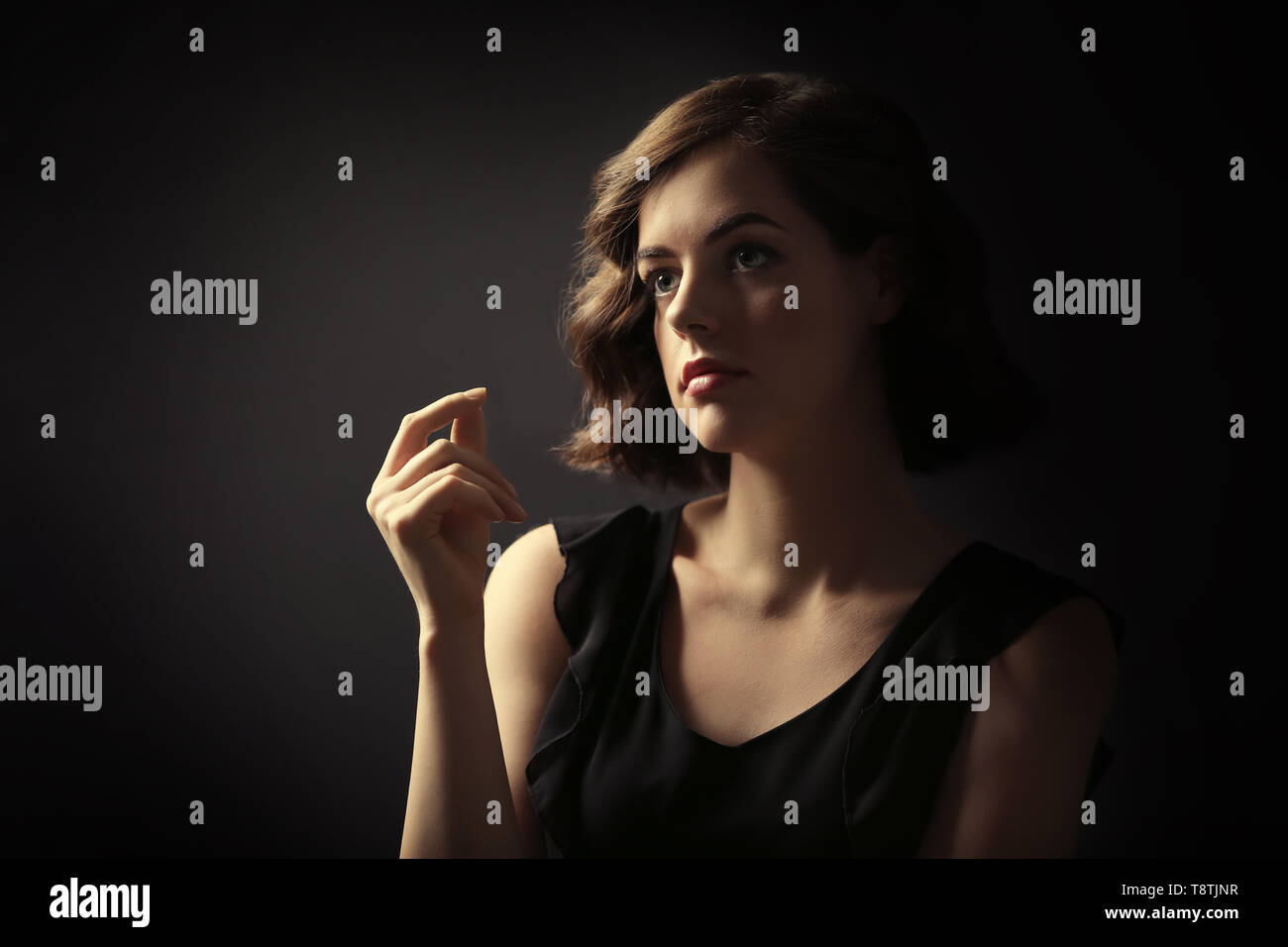 Portrait of beautiful young woman on dark background Stock Photo - Alamy