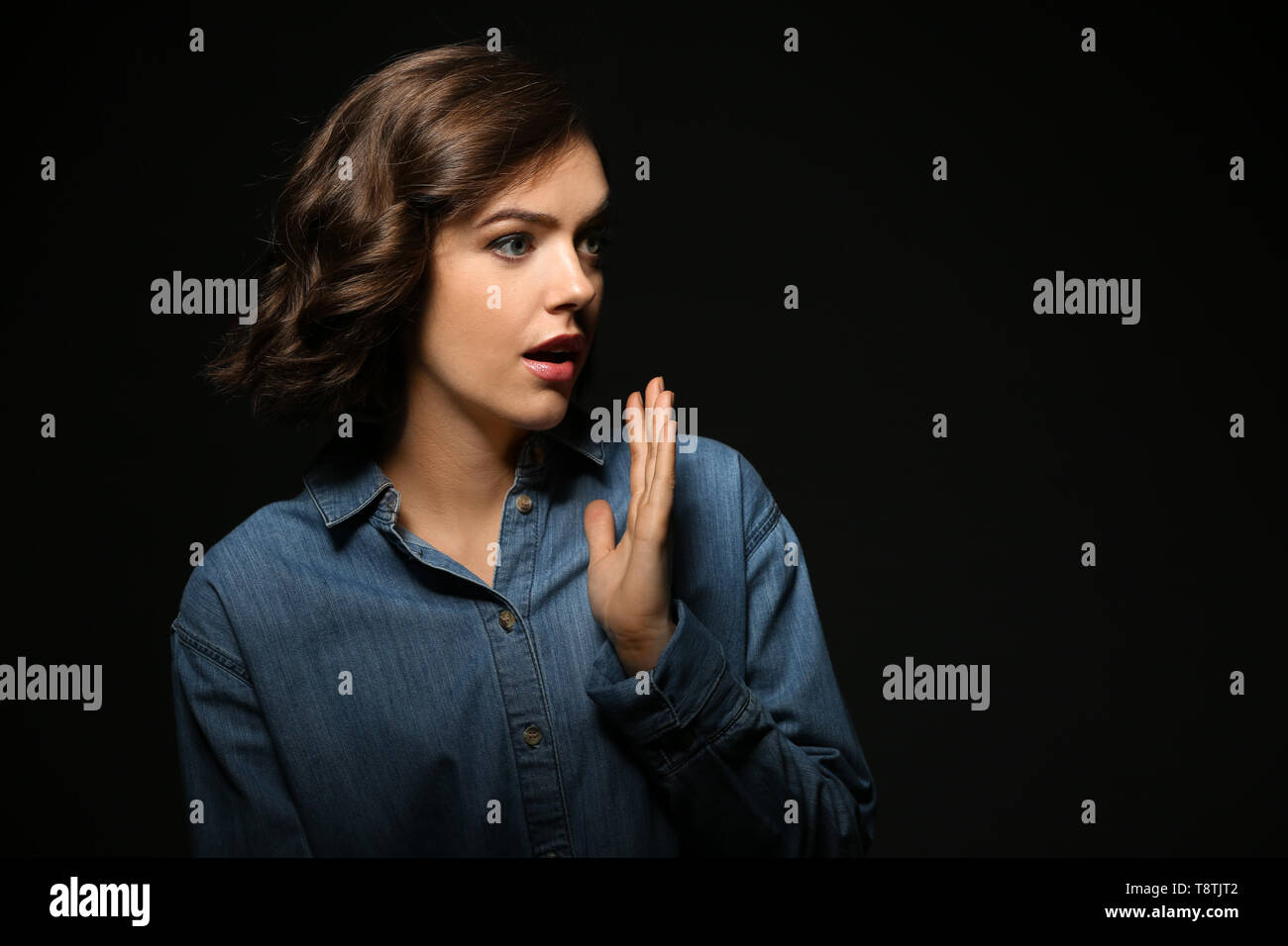Portrait of surprised young woman on dark background Stock Photo - Alamy