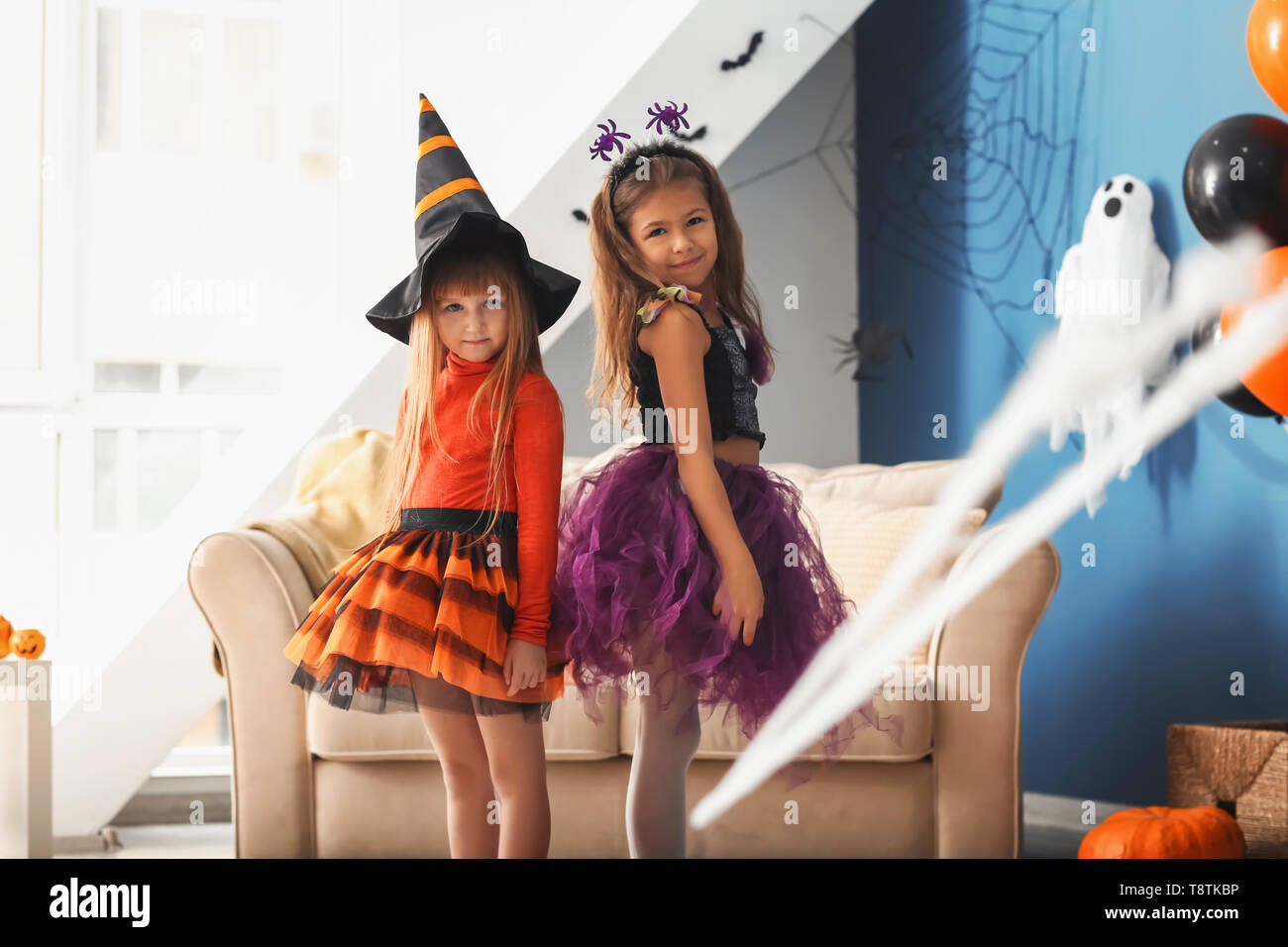 Cute little girls in Halloween costumes at home Stock Photo Alamy